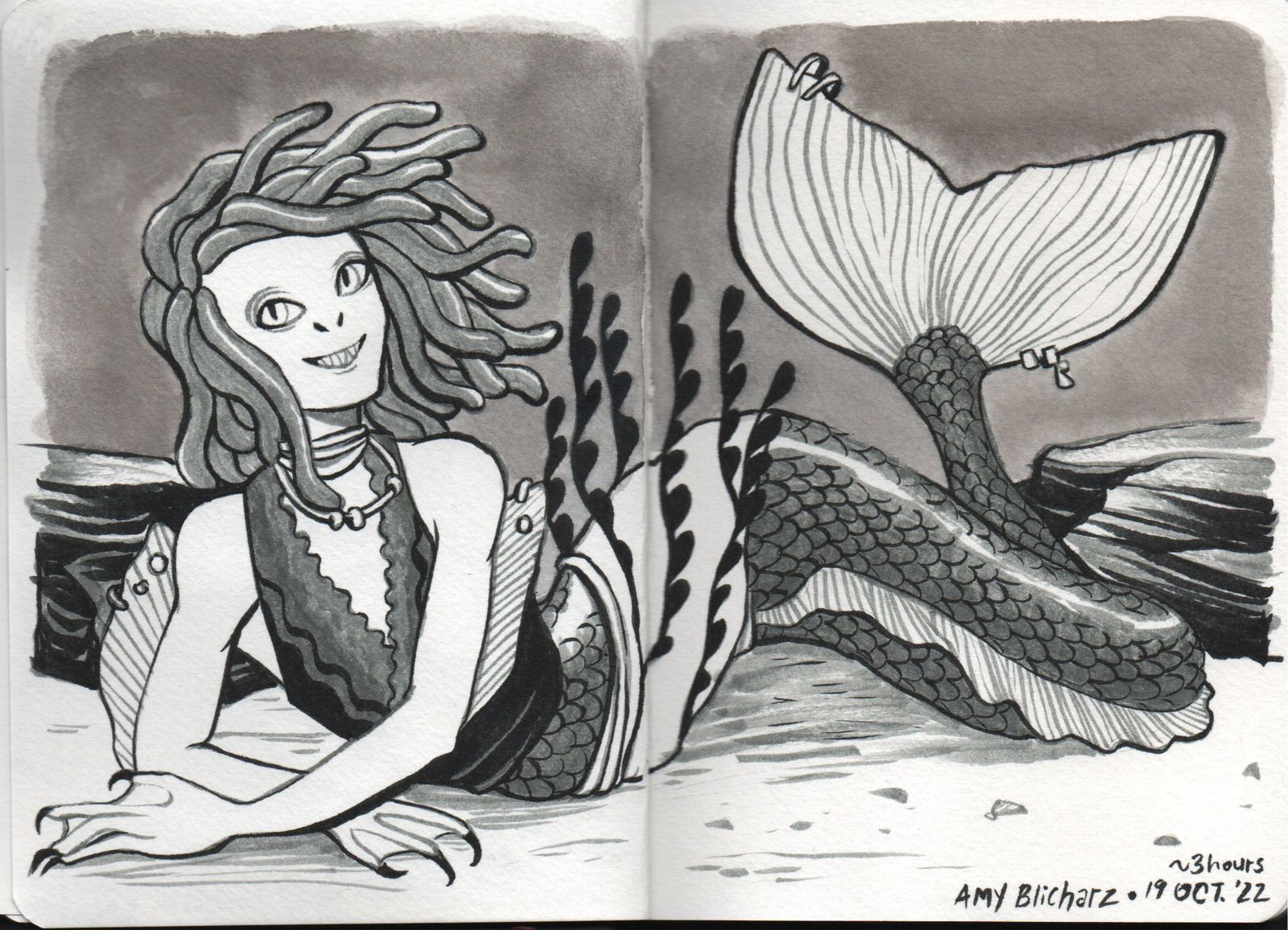 A teenage mermaid lounges on the ocean floor