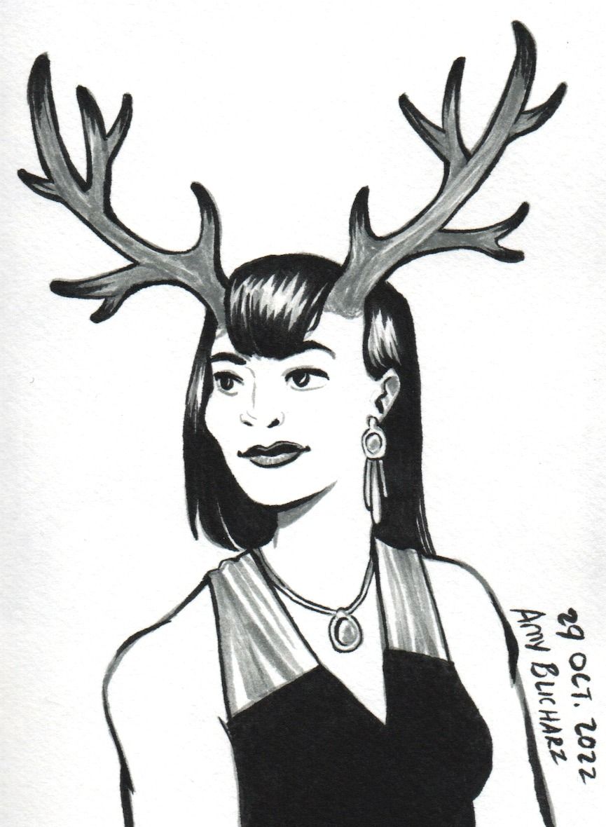 A woman with antlers and wearing fancy dress looks to the side